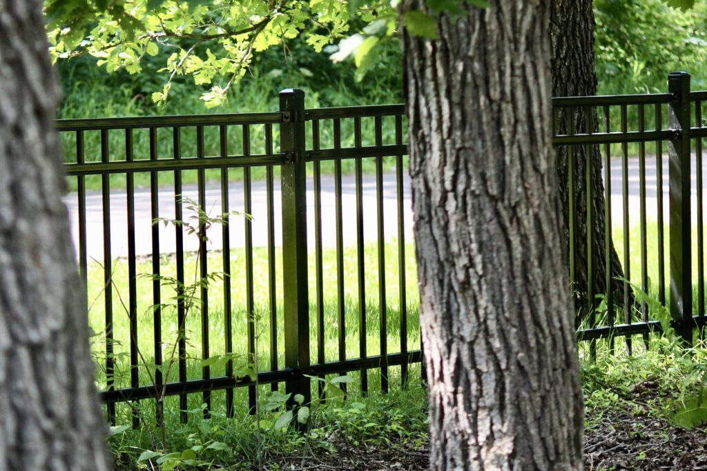 Close-up view of Residential Ornamental Fencing in Winnipeg between trees in natural setting