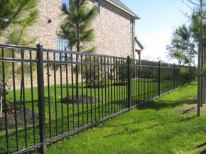 Black Majestic Ornamental Fence n Winnipeg running along green space with mature trees in foreground