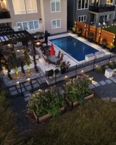 Backyard pergola and outdoor kitchen beside ornamental pool fence in Winnipeg